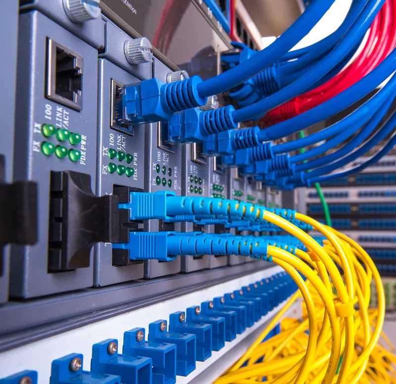 Técnico organizando rack e cabeamento estruturado